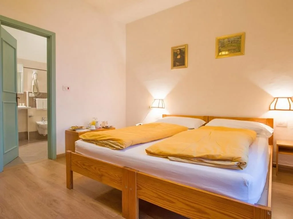Camera con letto matrimoniale, coperte gialle e bagno privato adiacente