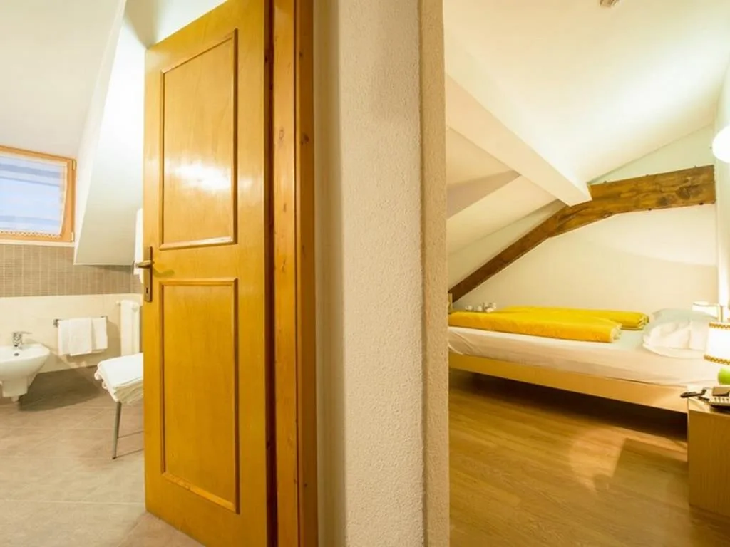 Camera mansardata con letto e bagno privato adiacente