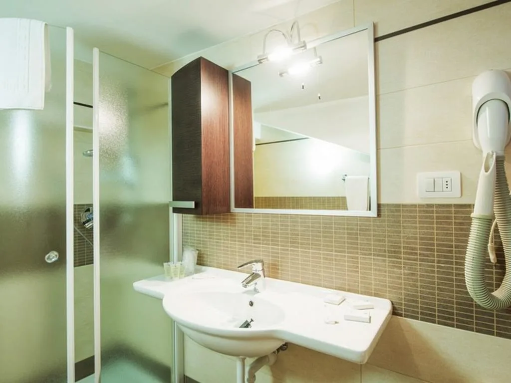 Bagno moderno con doccia, lavabo, specchio e asciugacapelli