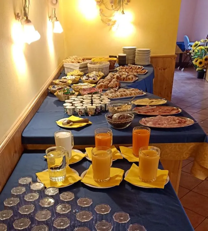 Ricco buffet della colazione con dolci, salumi, yogurt e succhi di frutta