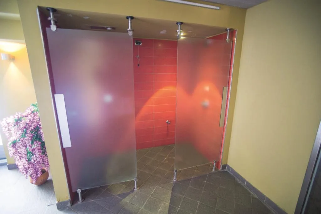 Cabina bagno turco con porte in vetro smerigliato e pareti interne rosse