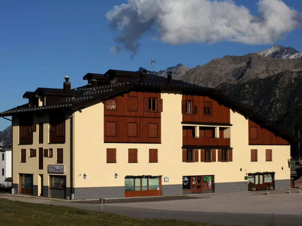 Esterno di edificio alpino in stile chalet con montagne rocciose sullo sfondo