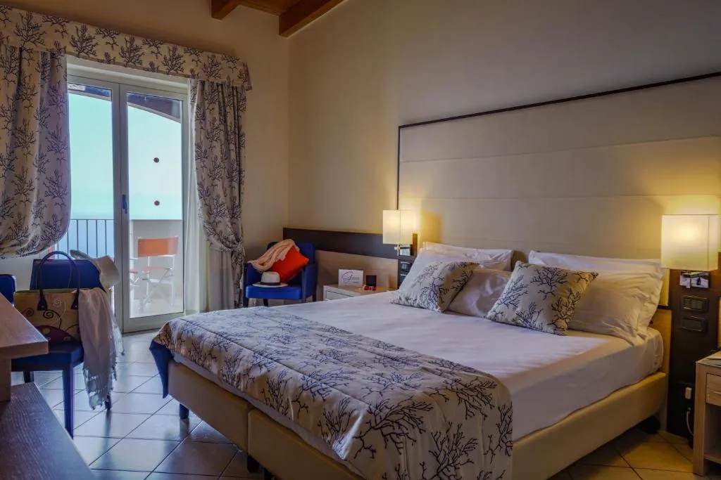 Camera elegante con letto matrimoniale e accesso al balcone vista mare