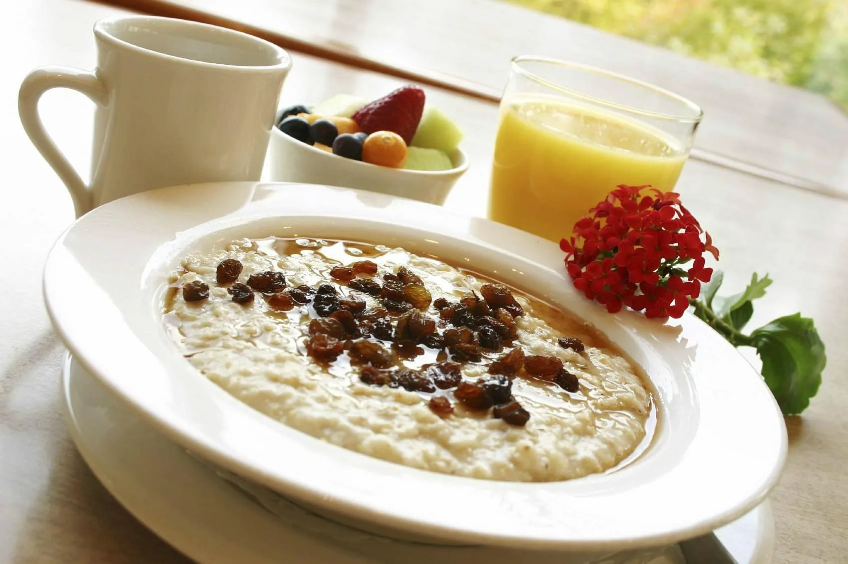 Colazione con porridge, frutta fresca e succo d'arancia