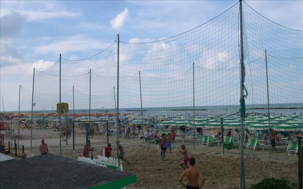 Spiaggia attrezzata con ombrelloni e campo da beach volley in riva al mare