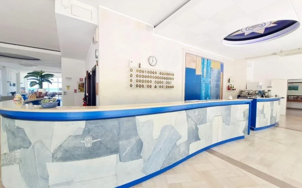Reception dell'hotel con lungo banco curvo azzurro e bianco