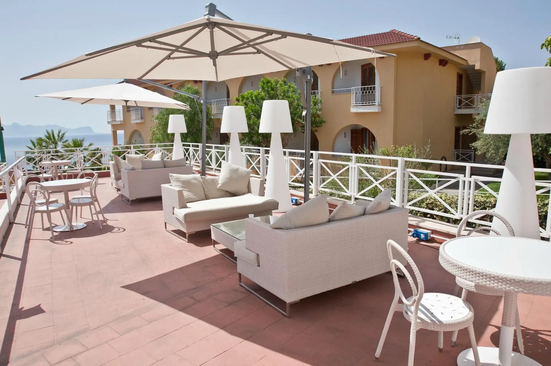 Terrazza lounge con divani, ombrelloni e vista mare