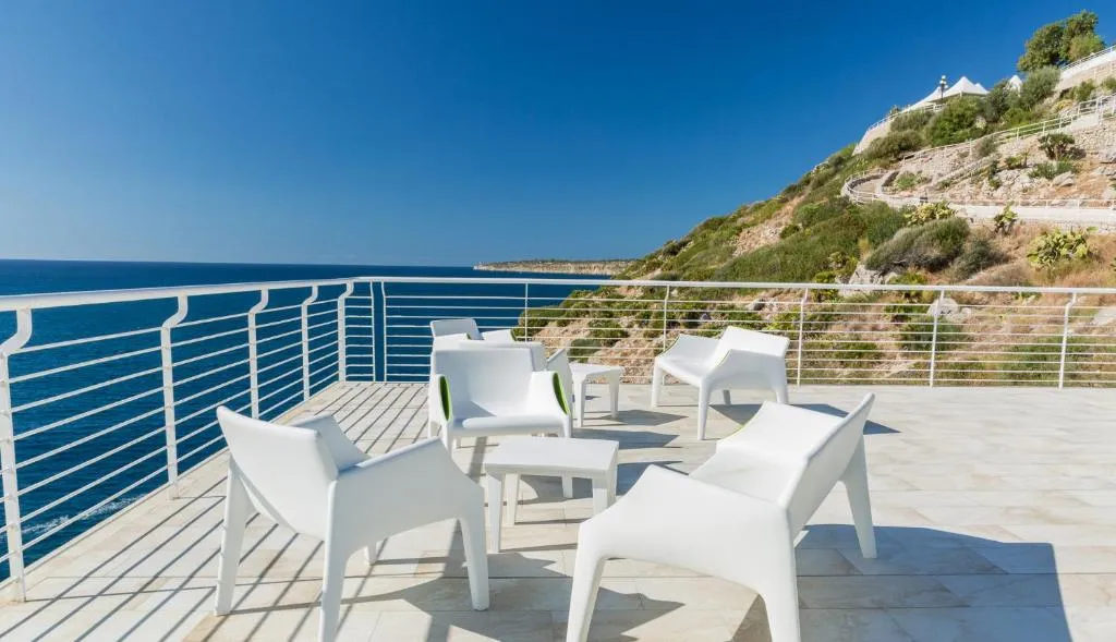 Terrazza panoramica con poltrone bianche affacciata sul mare