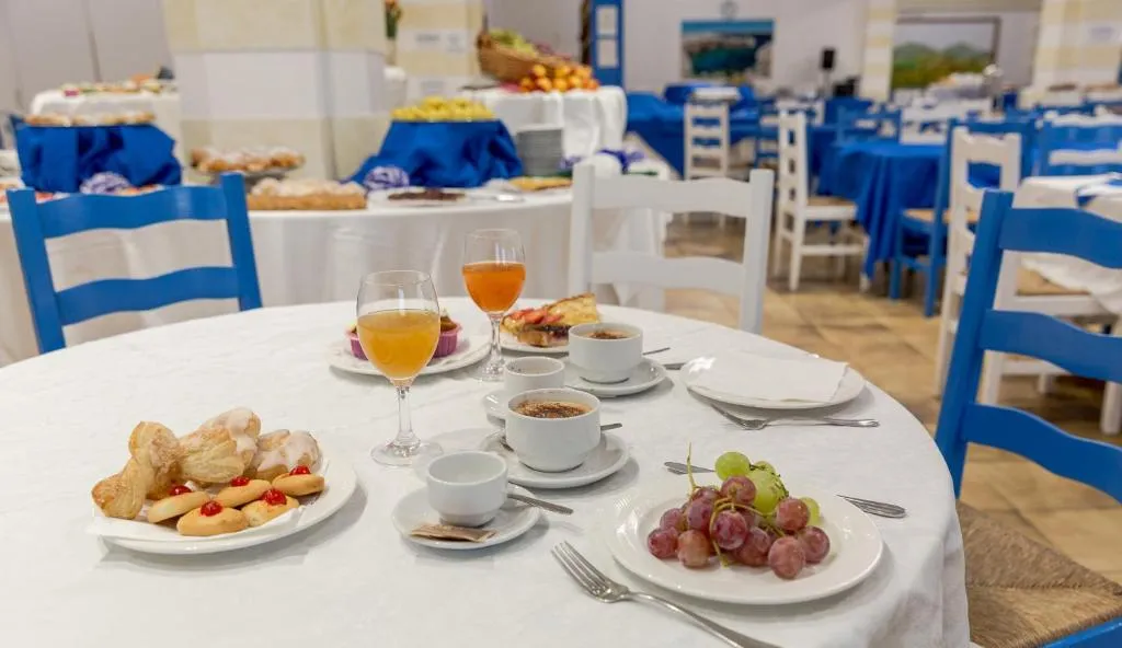 Tavolo colazione con dolci, frutta e bevande nella sala dai colori blu