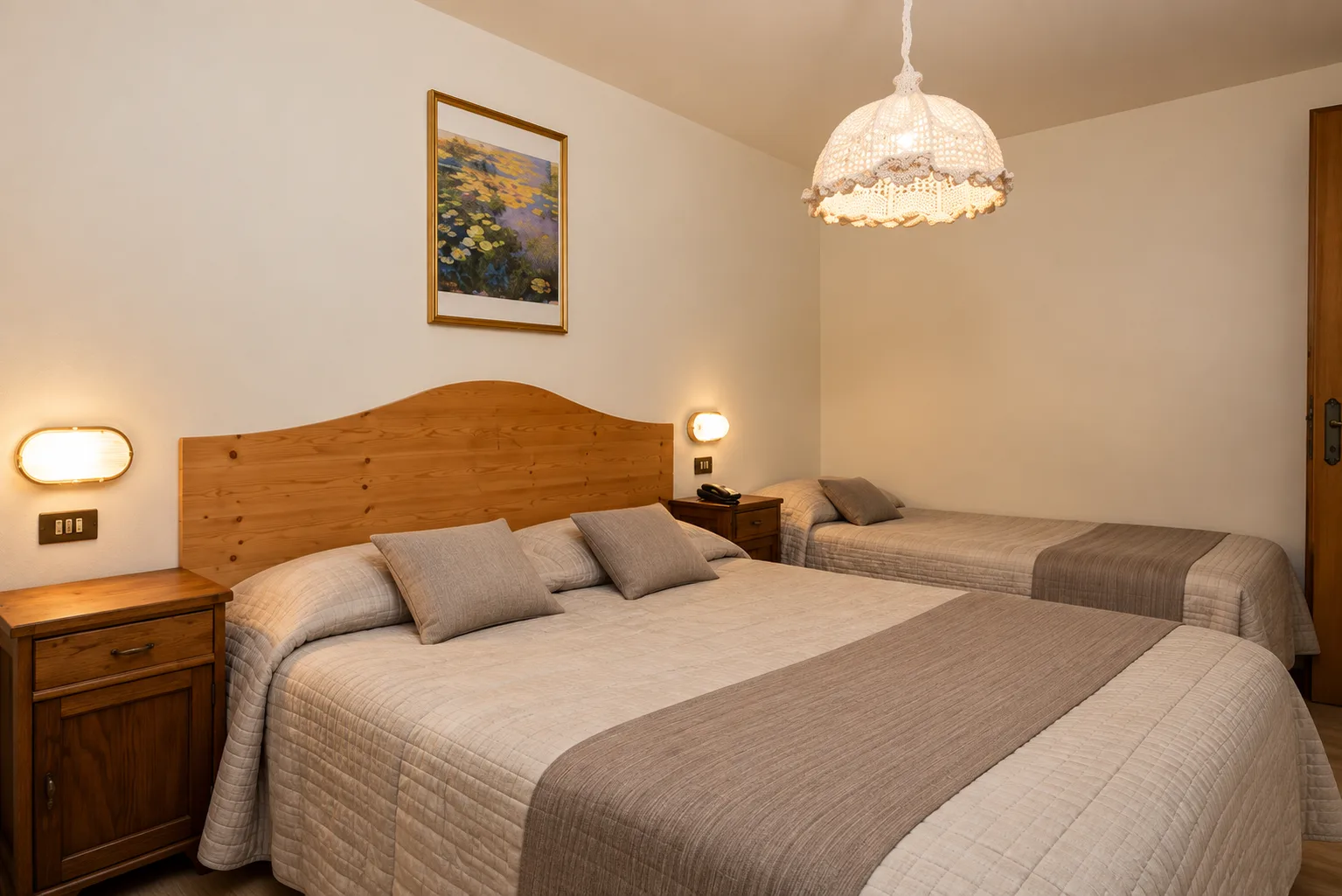 Camera tripla con letto matrimoniale e letto singolo, testiera in legno e comodini