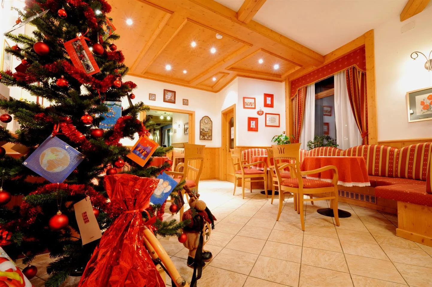 Sala interna con albero di Natale addobbato e arredi in legno