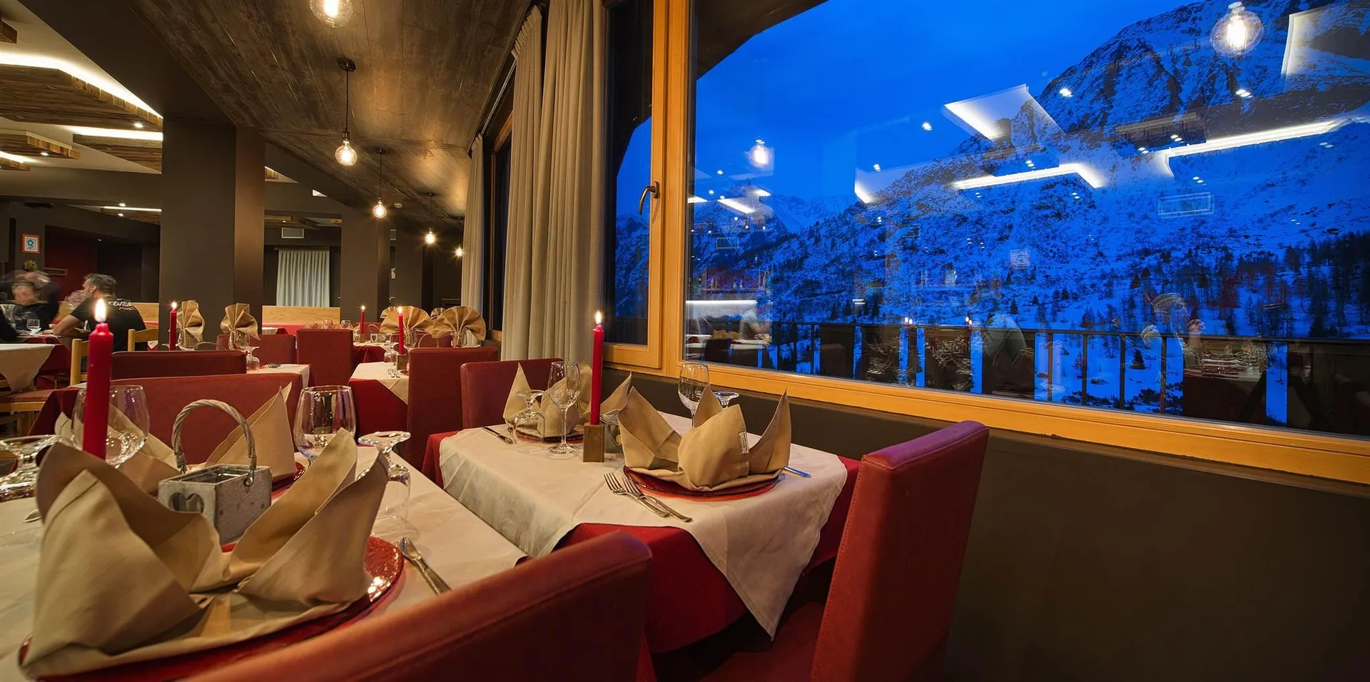 Ristorante con tavoli eleganti e ampie vetrate sulla montagna al crepuscolo