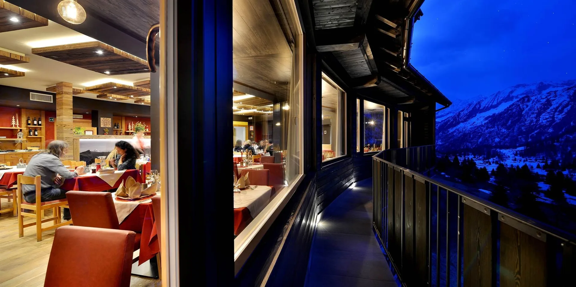 Balcone del ristorante con vista notturna sulle montagne innevate