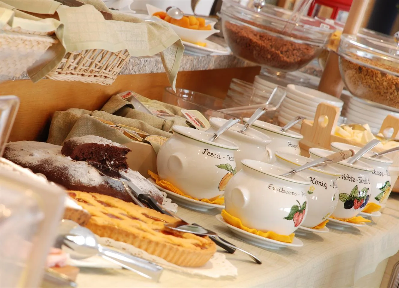 Buffet dolci con crostate, torta al cioccolato e vasetti di marmellata