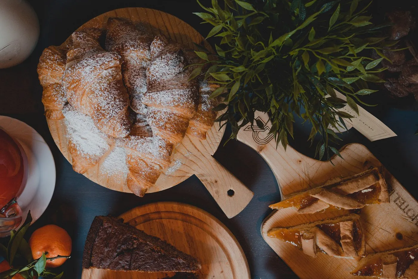 Composizione di cornetti, torte e crostate su taglieri di legno vista dall'alto
