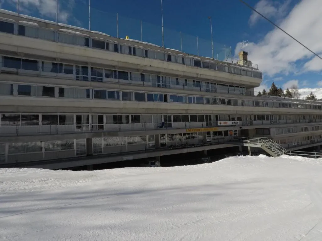 Facciata dell'edificio in inverno con neve e insegna del bar ristorante