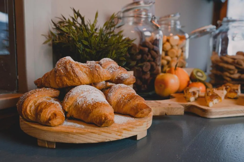Cornetti spolverati di zucchero a velo e frutta al buffet della colazione